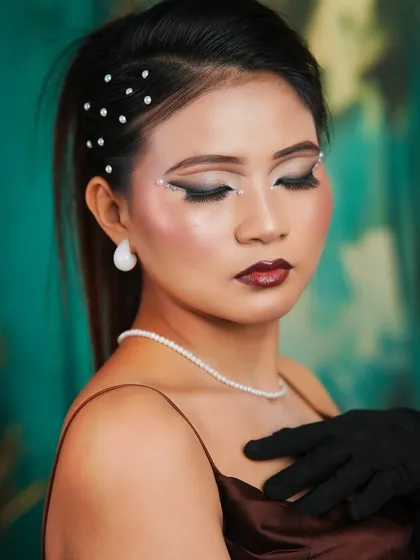 A close-up of the editorial look, with the model's eyes closed to showcase the intricate pearl and eyeliner details.