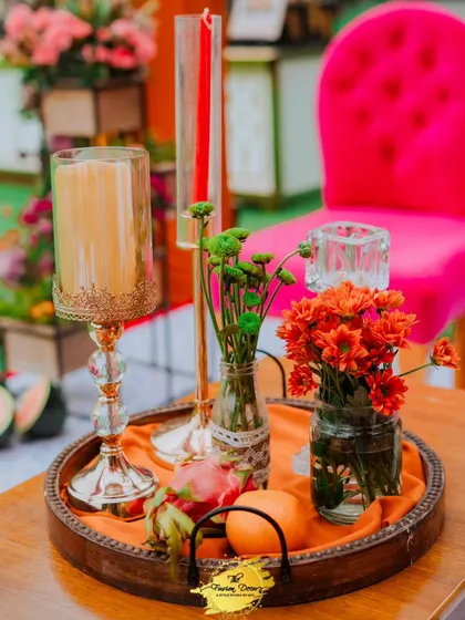 A beautiful tabletop tray arrangement with candles and small vases of flowers. The fresh oranges and dragon fruit add an unexpected and colourful twist.