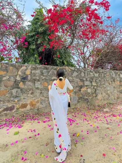 A back view showing the simple bun with a gajra and the elegant drape of the white mul cotton saree. Sometimes the most beautiful statements are the simplest.