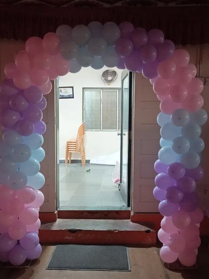 A simple and sweet balloon arch in pastel pink, blue, and purple, perfect for framing the entrance to a baby shower party.