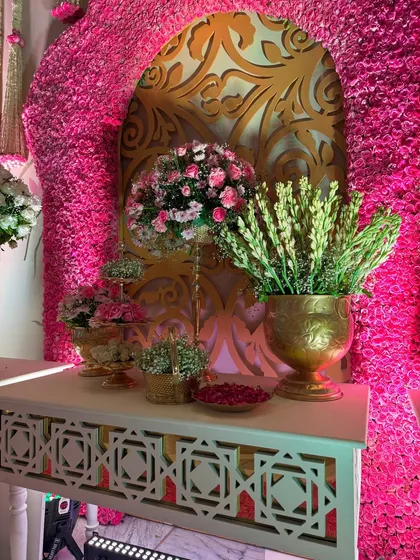 A close-up of the decor elements within the floral arch, including brass vases and beautiful arrangements, all contributing to the opulent, traditional aesthetic.