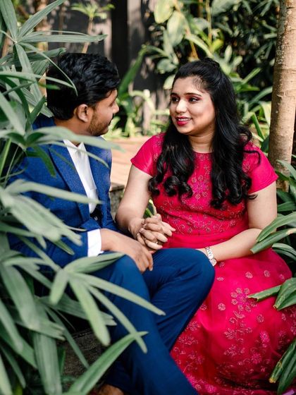An intimate shot from the couple's pre-wedding photoshoot. Her makeup is soft and pretty, designed to look flawless up close and complement her vibrant pink dress.