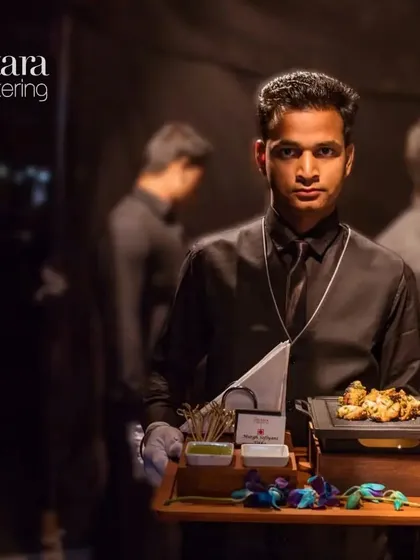Our attentive staff ensures that your guests are always catered to. This image shows one of our servers with a tray of freshly prepared appetizers, ready to serve.