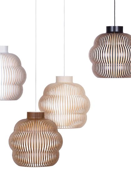 Four Kuulto pendants in white, natural birch, and walnut finishes are shown against a white background. This image clearly displays the different color and material options available for this versatile design.