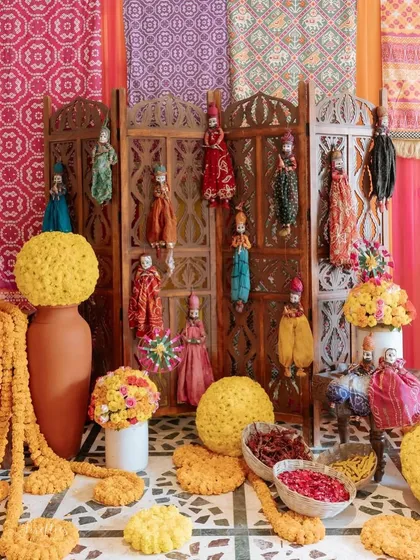 A vibrant corner filled with traditional Rajasthani puppets, marigold balls, and bowls of fresh flower petals. Every detail was curated to create an authentic and festive Mela atmosphere.