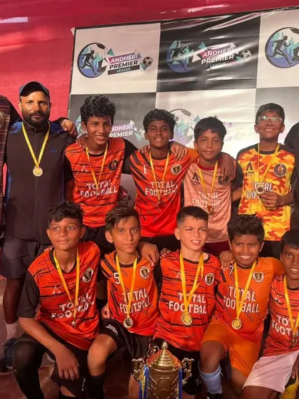 The U13 champions of the Andheri Premier League, posing with coaches after a dominant performance.