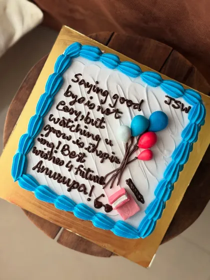 A thoughtful farewell cake for a colleague, with a handwritten message and cute balloon details.