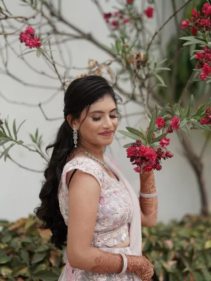 For pre-wedding events or receptions, I create modern, romantic looks like this one. Here, I've used soft pink tones on the eyes and lips to complement the bride's pastel lehenga, paired with a chic hairstyle and glowing skin.