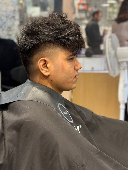 The final result of the men's curly haircut with a fade. The look is sharp, clean, and stylish.