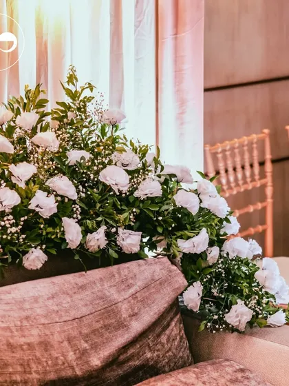 The couple's seating, enveloped in lush arrangements of white carnations and baby's breath. The soft textures and clean color palette created a serene and romantic focal point for the ceremony.