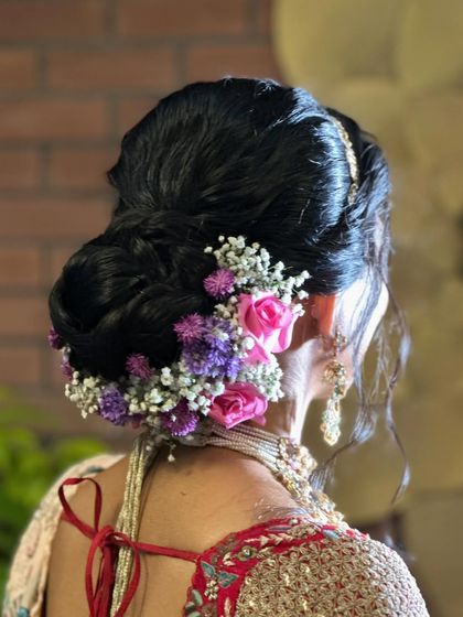 A closer look at the beautiful floral arrangement on this bridal bun, featuring a mix of roses and other delicate blooms for a fresh, garden-inspired feel.