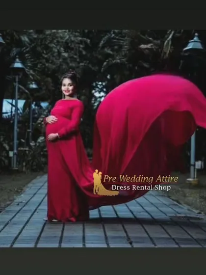 A solo portrait demonstrating the full effect of the magenta flying tail gown. The fabric billows out beautifully, creating a striking silhouette for a dramatic maternity photoshoot at dusk.