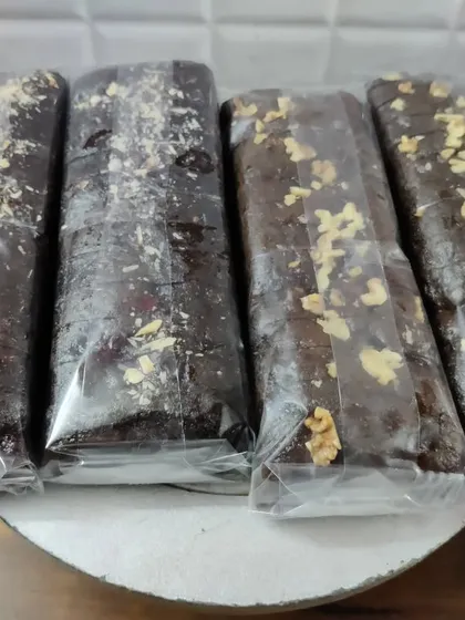 These are my chocolate loaf cakes, some topped with oats and nuts for extra texture and flavor. Each loaf is wrapped to keep it soft and fresh.