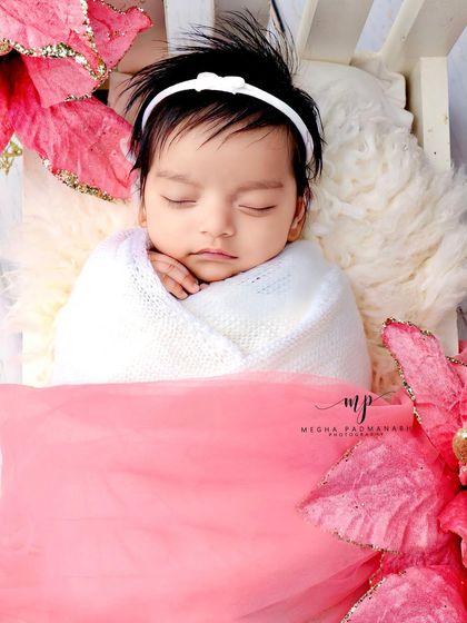 A portrait-style shot of the baby in the pink floral bed.