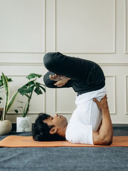 A variation of Sarvangasana (Shoulder Stand) with legs in a lotus position, showing flexibility and control.