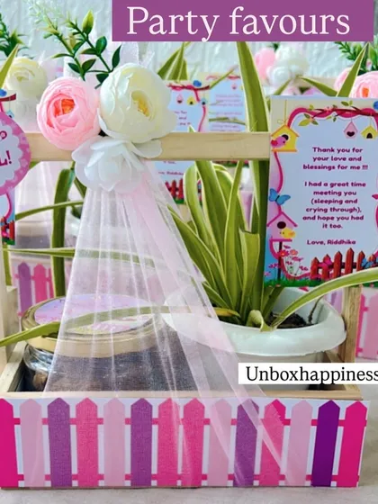 These party favors combine a lasting gift of a plant with a sweet treat. The pink picket-fence design makes it a charming choice for a baby girl's announcement or first birthday.