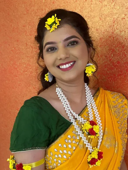 A happy and bright Haldi look. The bride is wearing beautiful handmade floral jewelry, and her makeup is kept simple and fresh to match.