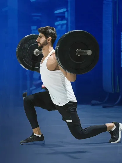 Pain is temporary, but gains are forever. A member executes a weighted lunge, an excellent exercise for building unilateral leg strength and stability.