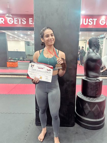 A student proudly shows off her silver medal and certificate. Every competition is a valuable learning experience.