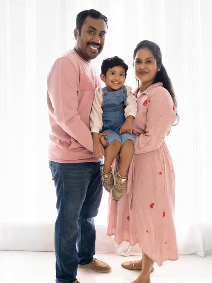 A standing portrait of the family, showcasing their coordinated outfits and happy expressions.