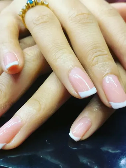 The epitome of timeless elegance. This is a close-up of our classic French manicure, featuring a flawless sheer pink base and crisp white tips on beautifully shaped squoval nails for a clean, polished finish.