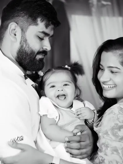 A happy black and white family portrait, capturing the love between parents and their laughing baby girl.