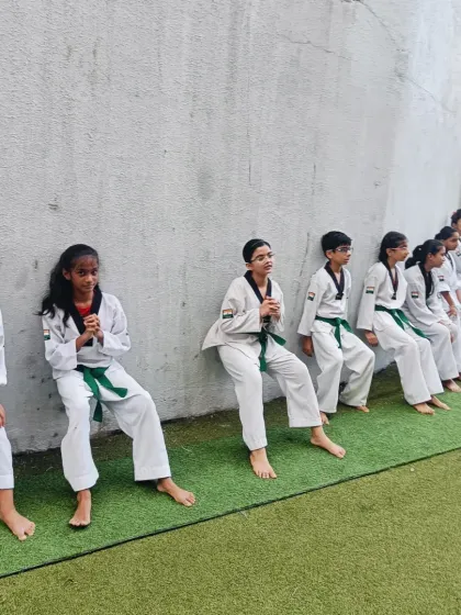 The entire class lines up for wall sits. This exercise builds not only physical endurance but also mental toughness and a sense of shared effort.