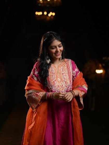 This pink and orange suit is perfect for a Mehendi night. The rich colors and detailed embroidery make it a festive and comfortable choice for an evening of dance and celebration.