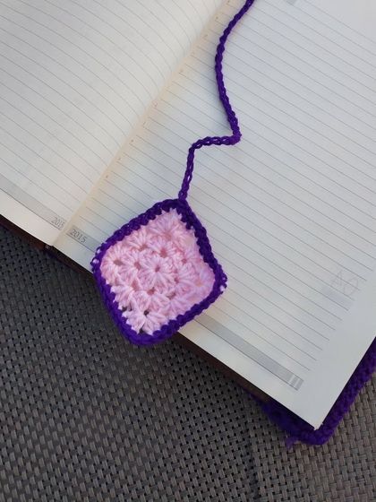 A custom crochet diary cover I made for 2025, featuring a granny square bookmark.