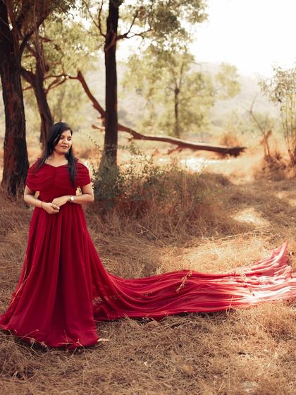 Lost in a forest fairytale. The long, elegant trail of this red gown spreads out beautifully, creating a stunning visual for a pre-wedding or maternity shoot in nature.