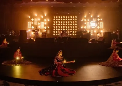 Dancers perform a piece with traditional diyas, adding a beautiful, serene element to the live show. We choreograph these moments to create visual highlights that punctuate the musical performances.