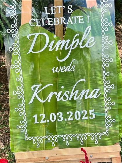 We designed this unique welcome sign for a wedding using a clear acrylic panel placed over a large banana leaf. The white script and traditional border design create a beautiful fusion of modern and authentic styles.