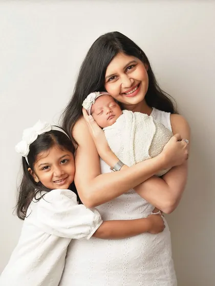 A mother and her two daughters share a hug. This photo is filled with warmth and the special bond between a mom and her children.