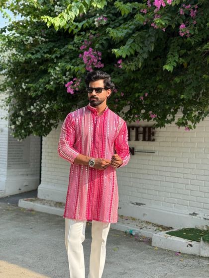 The vibrant pink and white stripes of this modern kurta create a visually appealing pattern. It's a versatile piece that can be dressed up or down for various festive occasions.