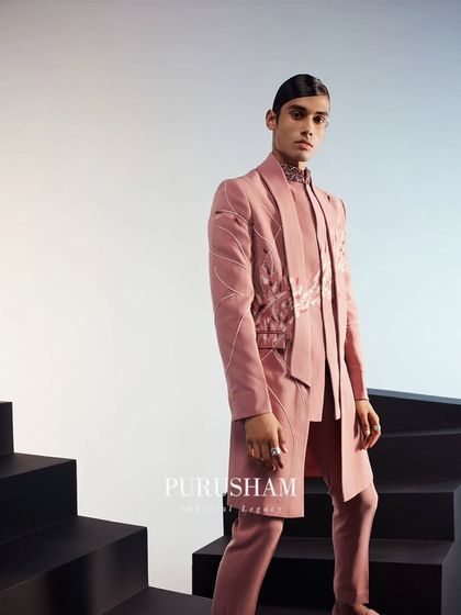 A full-length view of the peach-toned modern sherwani. The clean lines and sharp tailoring are complemented by delicate embroidery, capturing the magic of the season.