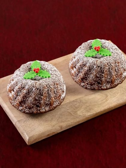 Our mini rum-soaked Plum Cakes are perfect for individual enjoyment or as a small, thoughtful gift. They are dusted with powdered sugar and topped with a holly decoration.