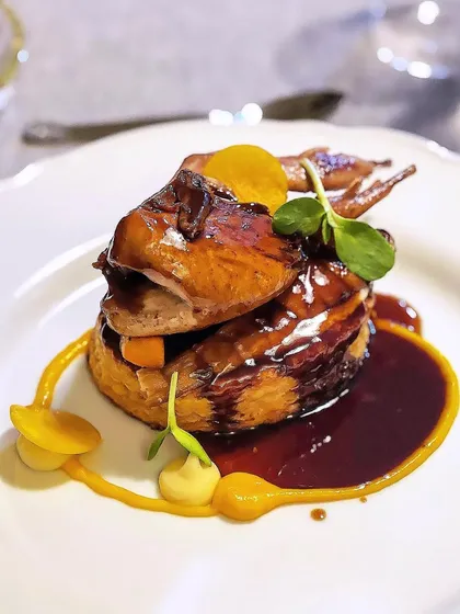 A tribute to classic French cuisine: "Caille en sarcophage," or quail in a coffin. A whole roasted quail is presented in a puff pastry coffin, a dramatic and delicious entrée.