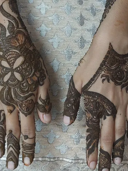 An example of how I can create different but complementary designs on each hand. One hand features a bold floral pattern while the other has a more geometric Arabic style.