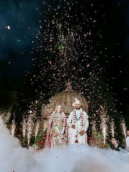 A truly royal Varmala ceremony in Jaipur, with the couple on a stage designed to look like a palace dome, complete with fireworks and dramatic smoke.