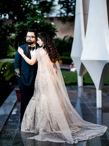 A romantic portrait showcasing the bride's stunning gown with a long, flowing cape.