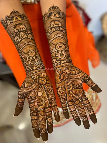 A grand bridal design featuring elephants, architectural domes, and intricate patterns. The full coverage from fingertips to elbows is perfect for a traditional wedding.
