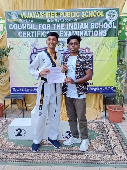As a coach, my greatest achievement is seeing my students become champions. Here I am with a student on the podium at a school-level competition.