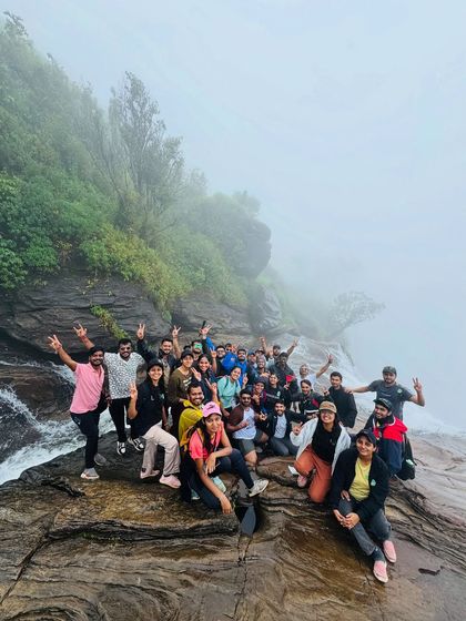 A classic group photo at the top of Bandaje Falls. The smiles say it all, even with the mist rolling in.