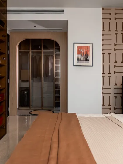 A view into the walk-in wardrobe from the son's bedroom. The arched doorway and glass doors create an inviting and elegant transition, showcasing our attention to detail in every part of the home.