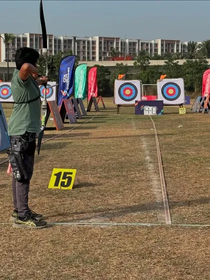 A young archer competes at the SFA Championships, focusing intently on the target downfield.