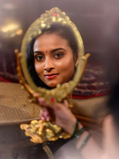 An artistic shot using a vintage mirror as a prop. This 'Kanmani' concept captures a sense of intimacy and self-reflection, perfect for a conceptual ethnic shoot.
