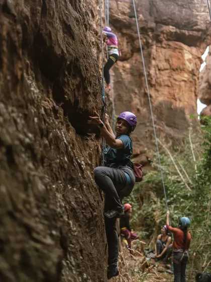 Two climbers simultaneously ascending parallel routes in Badami. Our events create a dynamic environment where everyone can climb and learn together.