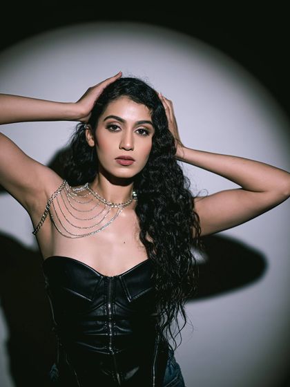 The dramatic lighting in this shot creates interesting shadows, showcasing the sculpted makeup.