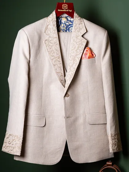 An example of our precision tailoring in an Indo-Western suit. Note the intricate embroidery on the lapels and cuffs, paired with a vibrant pocket square and a unique inner lining, showcasing how details create a distinctive identity.