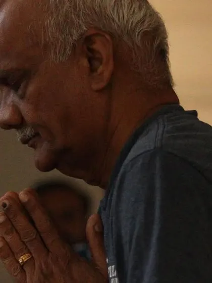 A participant finds a moment of quiet gratitude during a healing session. The practice of turning inward with prayer or intention is a powerful part of the healing process we cultivate here.
